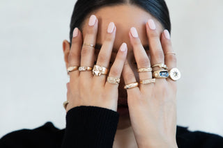 Model wearing multiple stacked gold chunky rings
