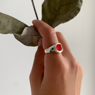 Model wearing recycled silver signet ring with cabochon red gemstone