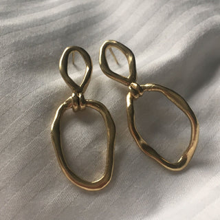 Gold plated Puddle drop earrings handmade sustainably by Claire Hibon from recycled and reused material on a soft background.
