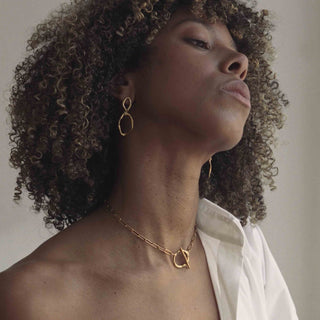 Model showcasing sustainable Claire Hibon jewellery for sale on Pearls & Pomegranates including the Puddle choker necklace.