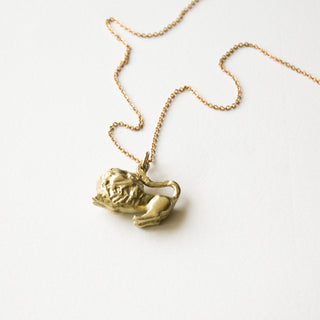 Recycled brass lion pendant on its side