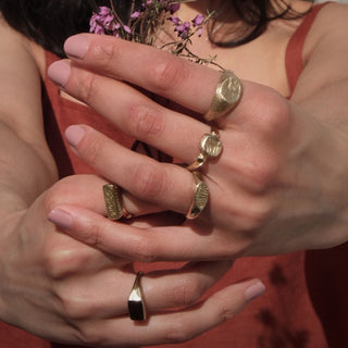 Model wearing collection of rings including the Melt signet ring by Lunaflux.