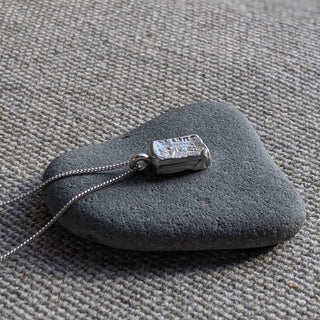 Recycled silver pendant, the Sophia pendant by Lunaflux, on an organic background.