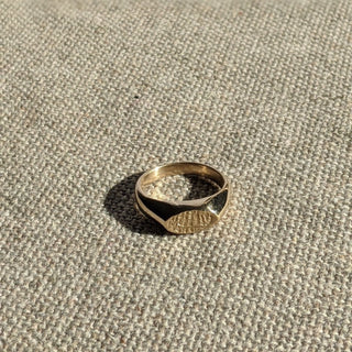The Lamina signet ring in brass handcrafted by Lunaflux on a linen background.