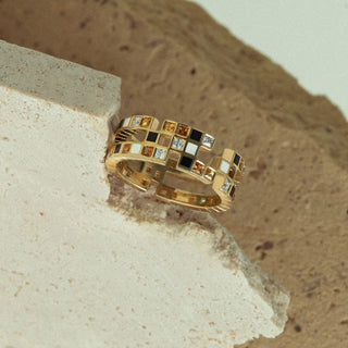 Lifestyle image of statement Chichi ring by EDXU in recycled 18ct yellow gold with orange, yellow, and black gemstones